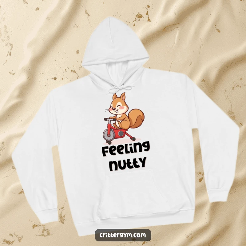 Funny hoodie, cute squirrel performing a leg kick on a small red exercise bike, cozy fitness gear.