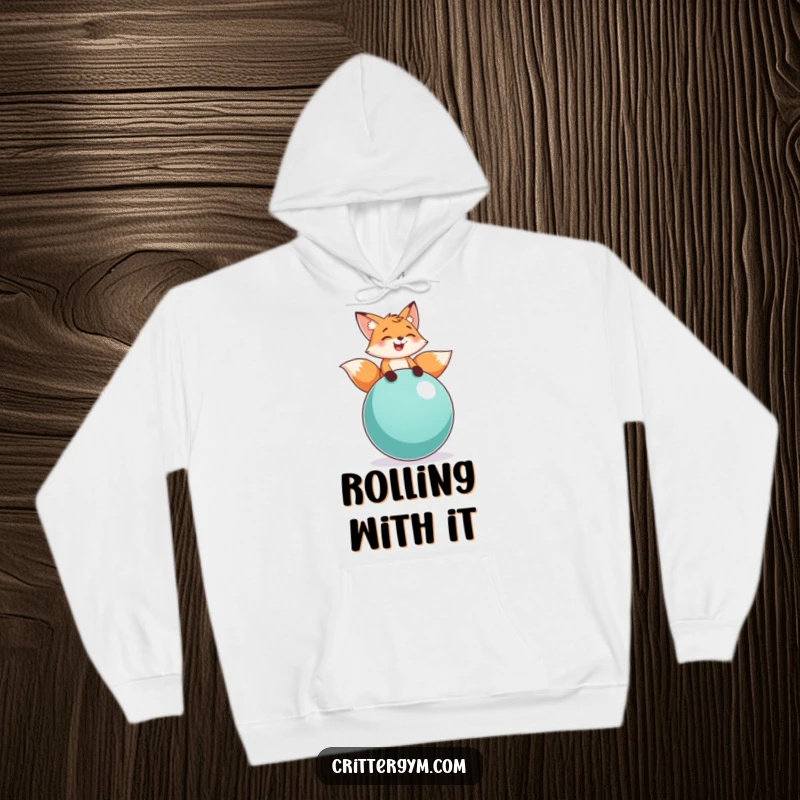 Funny fox balance hoodie with a playful fox character laughing while balancing on a large exercise ball, offering cozy and comical style.