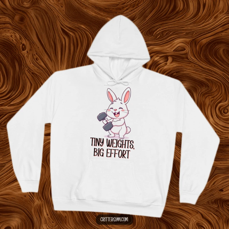 Funny rabbit gym hoodie with a smiling rabbit character comically failing to lift a tiny dumbbell, offering cozy workout humor.