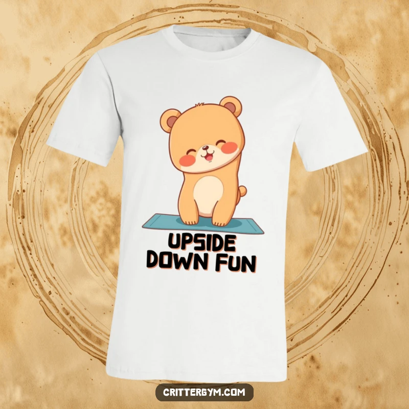 Funny t-shirt depicting a giggling bear cub struggling to maintain a handstand on a yoga mat with a smile.